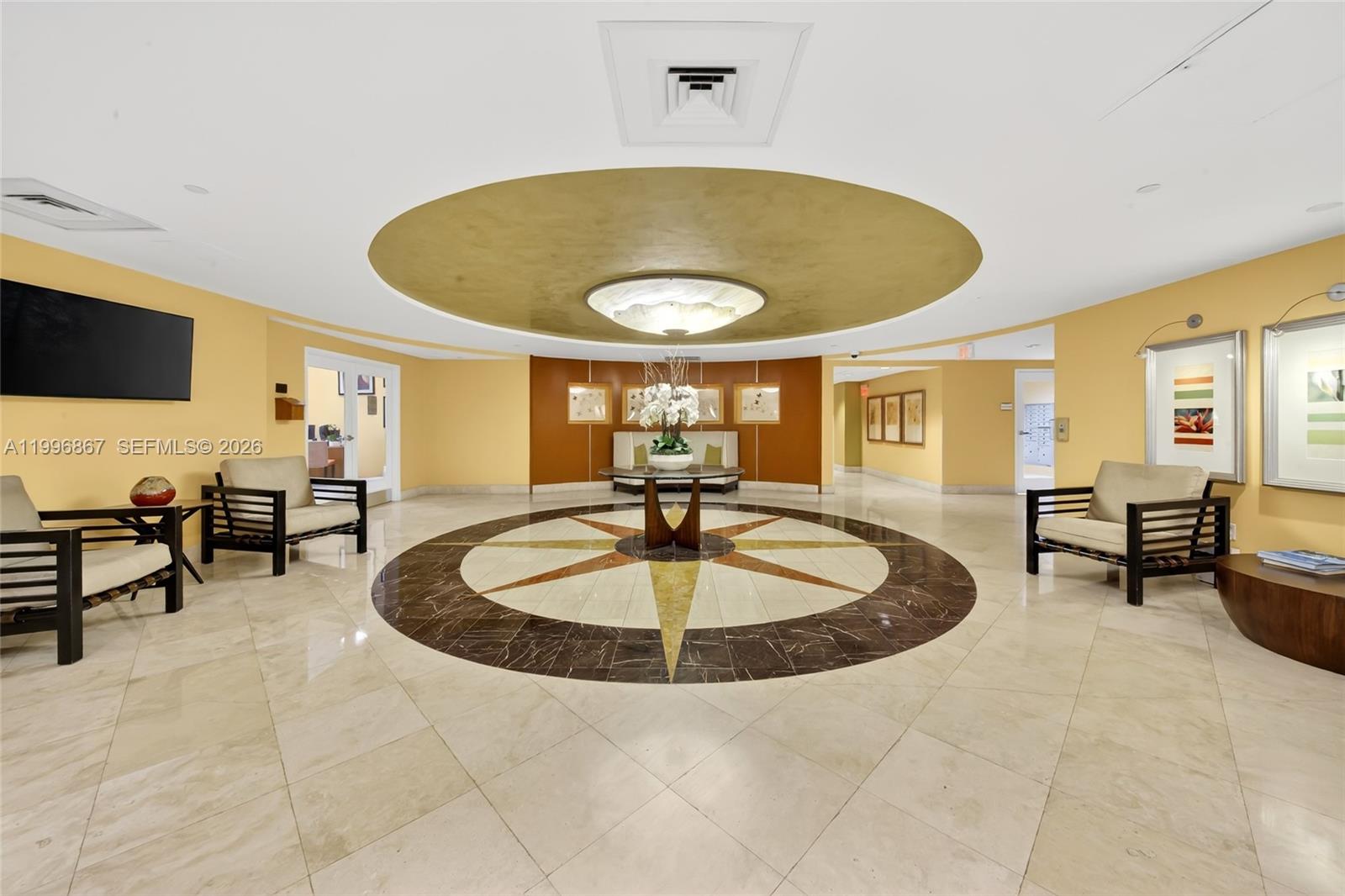 This lobby features a circular floor inlay, a central table, and seating areas — 7350 SW 89th St # 1703S, Miami FL 33156, MIAMI, FL