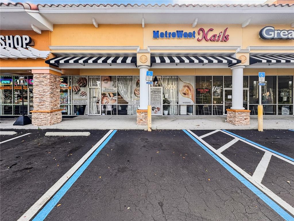 The exterior of a retail strip mall features a nail salon and a hair salon — 2607 S HIAWASSEE ROAD, ORLANDO, FL