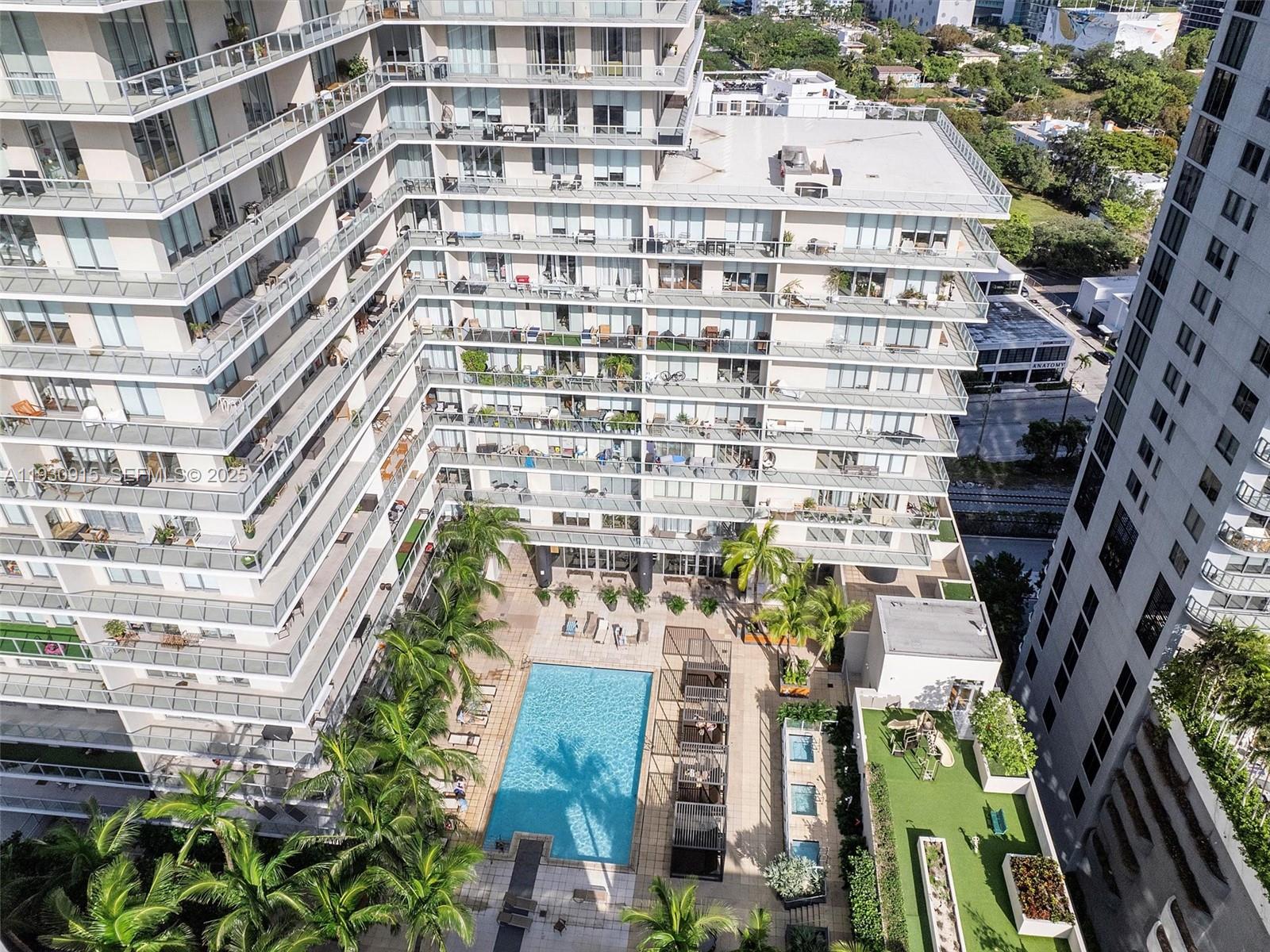 An aerial view of a multi-story apartment building with a central pool and courtyard — 3470 E Coast Ave # H1605, Miami FL 33137, MIAMI, FL