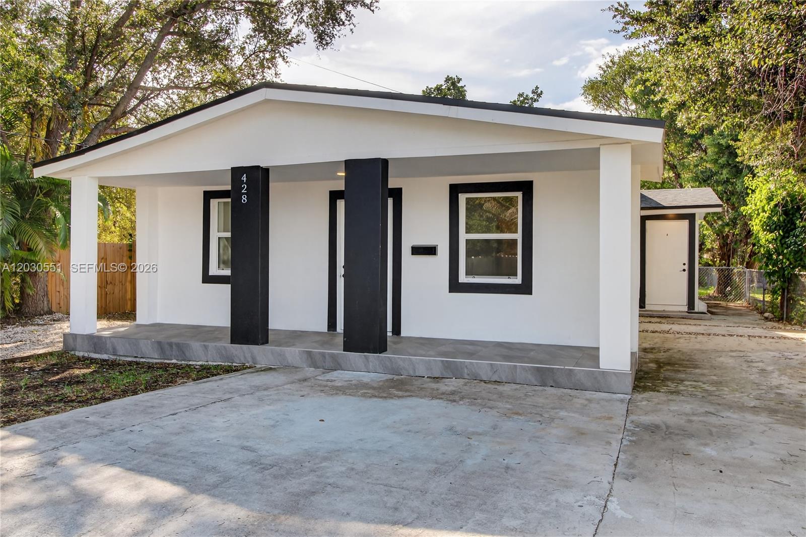A white house with black trim and two black support pillars on a front porch — 428 NW 97th St, Miami FL 33150, MIAMI, FL
