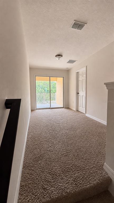 A carpeted landing leads to a sliding glass door opening onto a balcony — 13483 GORGONA ISLE DRIVE, WINDERMERE, FL