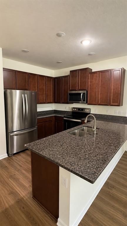 A kitchen features dark wood cabinets, granite countertops, stainless steel appliances, and a center island — 13483 GORGONA ISLE DRIVE, WINDERMERE, FL