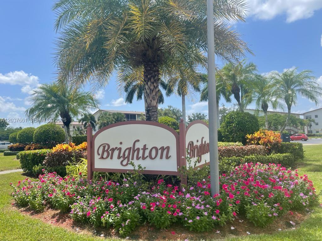 A sign for Brighton stands in a landscaped garden with palm trees and pink flowers — 366 Brighton I # 366, Boca Raton FL 33434, BOCA RATON, FL