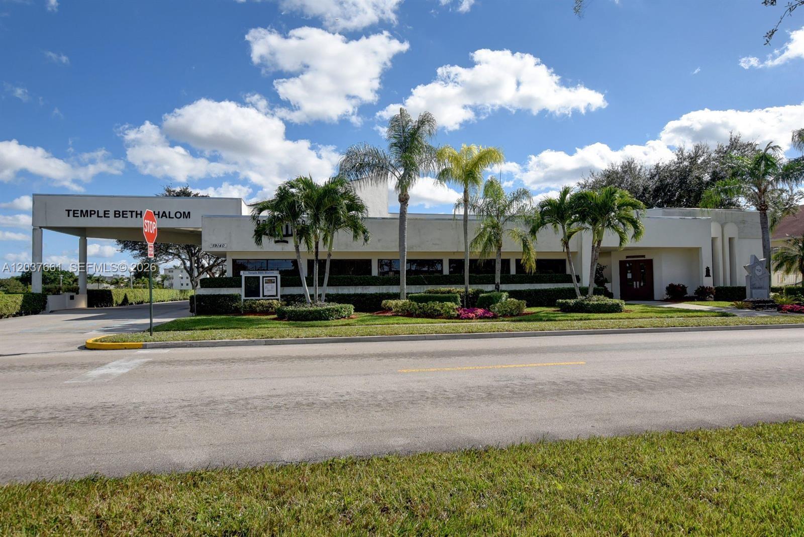 A low-rise building with a covered entrance and palm trees under a blue sky — 366 Brighton I # 366, Boca Raton FL 33434, BOCA RATON, FL