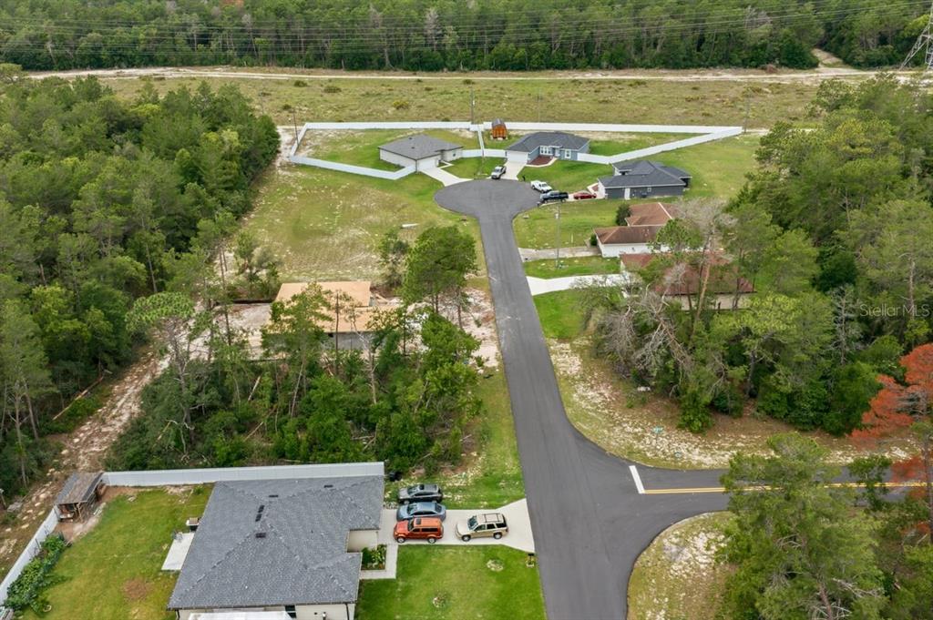 An aerial view shows a cul-de-sac with several houses surrounded by trees and vegetation — SW 165TH PLACE, OCALA, FL