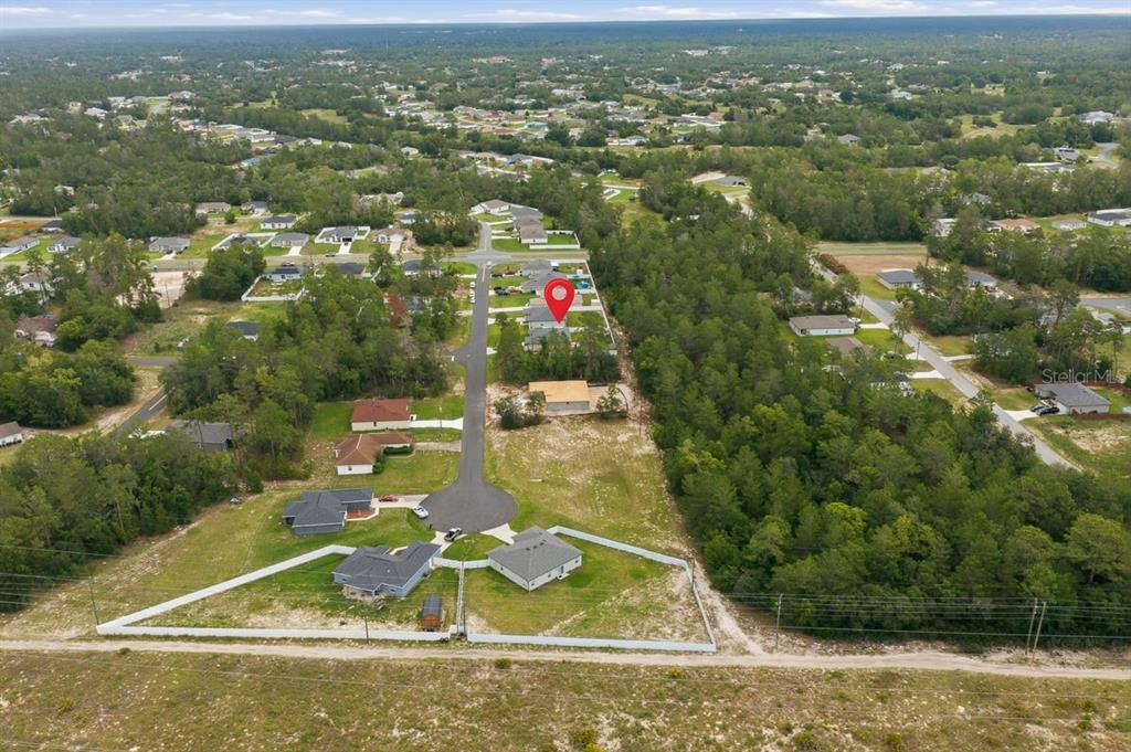 An aerial view shows a residential neighborhood with a red location pin on a house — SW 165TH PLACE, OCALA, FL