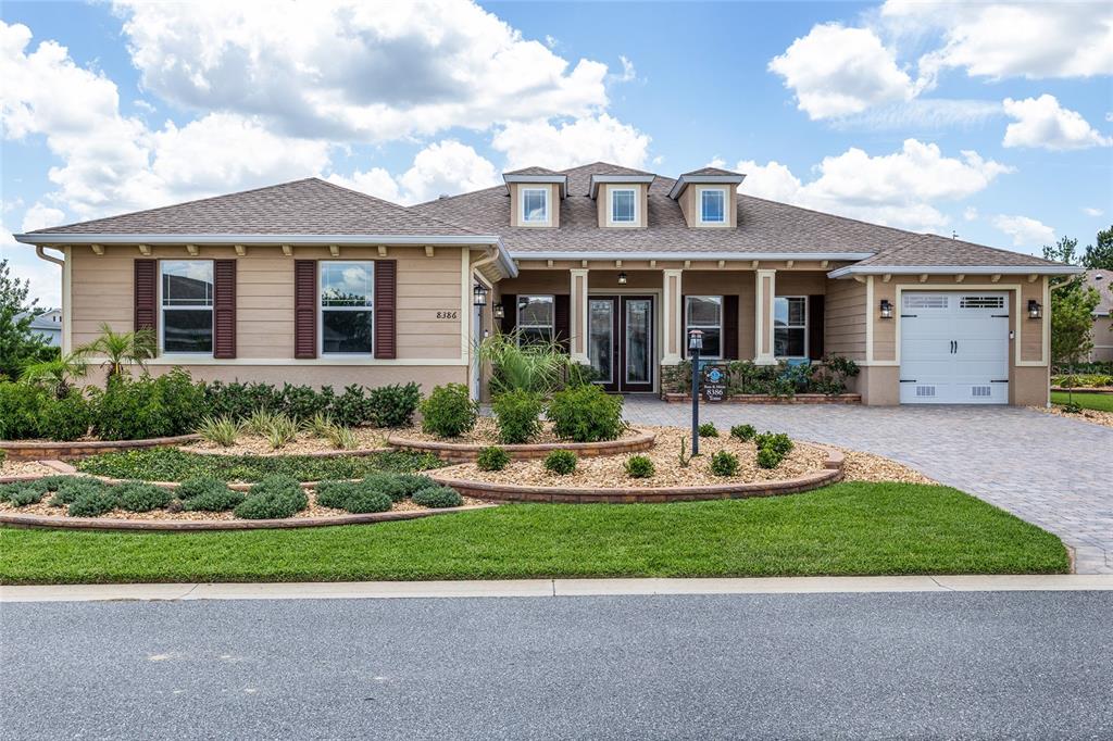 A single-story house with tan siding, a paved driveway, and a landscaped front yard — 8386 SW 90TH COURT, OCALA, FL
