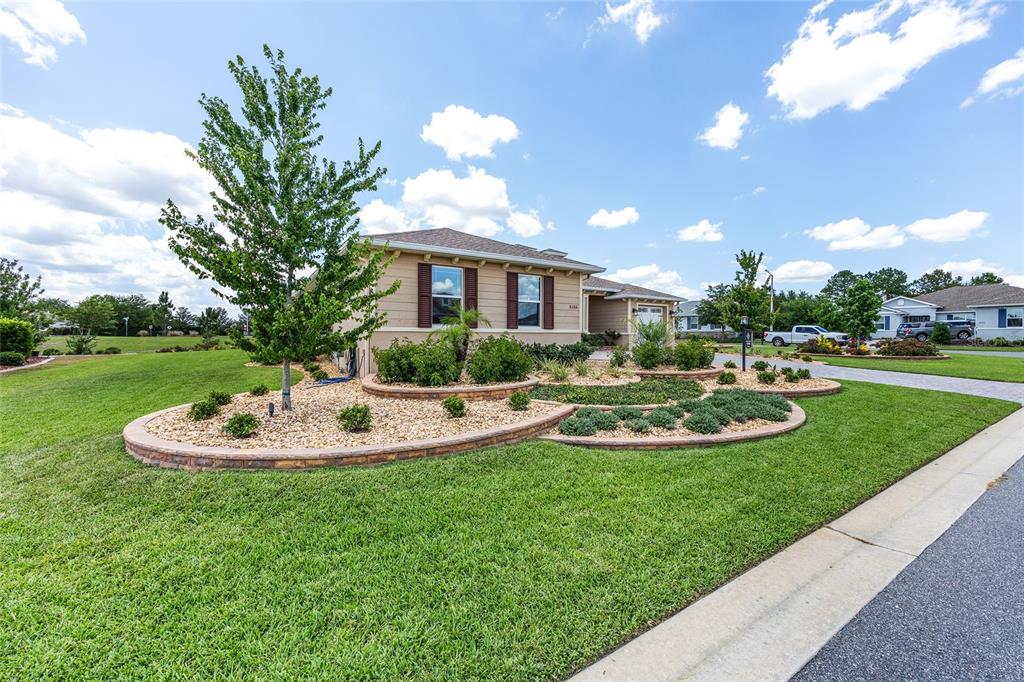 A single-story house features a tan exterior, brown shutters, and a landscaped front yard — 8386 SW 90TH COURT, OCALA, FL