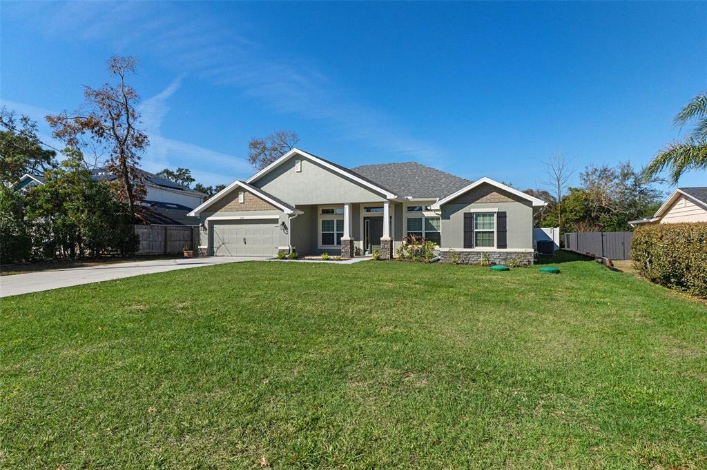 A single-story house with a gray exterior, stone accents, and a two-car garage — 5139 JENSON AVENUE, SPRING HILL, FL