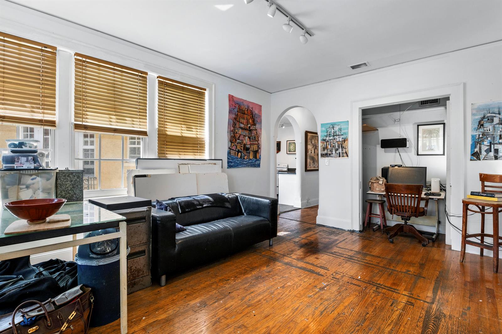 A living room with hardwood floors, a black sofa, and an adjacent office nook — 3224 Biscayne Boulevard # A3, Miami FL 33137, MIAMI, FL