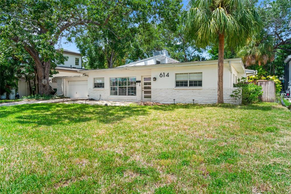 A single-story white house with a front lawn, a palm tree, and a garage — 614 ONTARIO AVENUE, TAMPA, FL