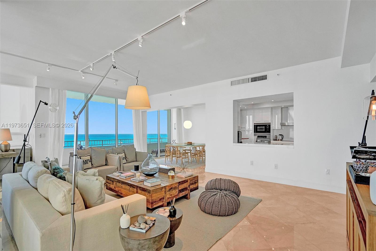 A bright living room features a large sectional sofa, a wooden coffee table, and ocean views — 10205 Collins Ave # P8, Bal Harbour FL 33154, BAL HARBOUR, FL