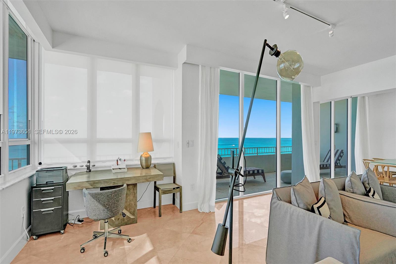 A bright living room with a desk, sofa, and floor-to-ceiling windows overlooking the ocean — 10205 Collins Ave # P8, Bal Harbour FL 33154, BAL HARBOUR, FL