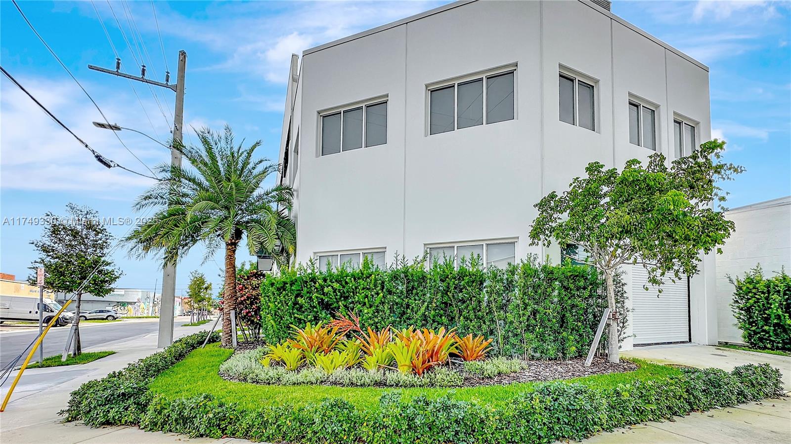 A white two-story commercial building features a landscaped corner lot with palm trees and shrubs — 6700 NE 2nd Ct # 4, Miami FL 33138, MIAMI, FL