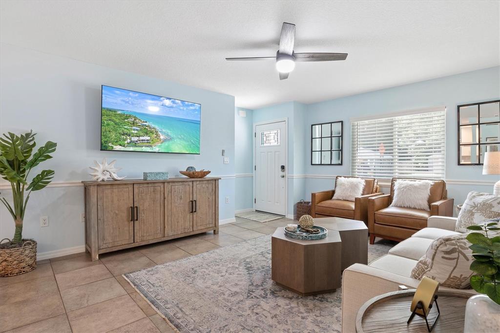 A living room features light blue walls, tile flooring, a television, and leather armchairs — 2729 SYDELLE STREET, SARASOTA, FL