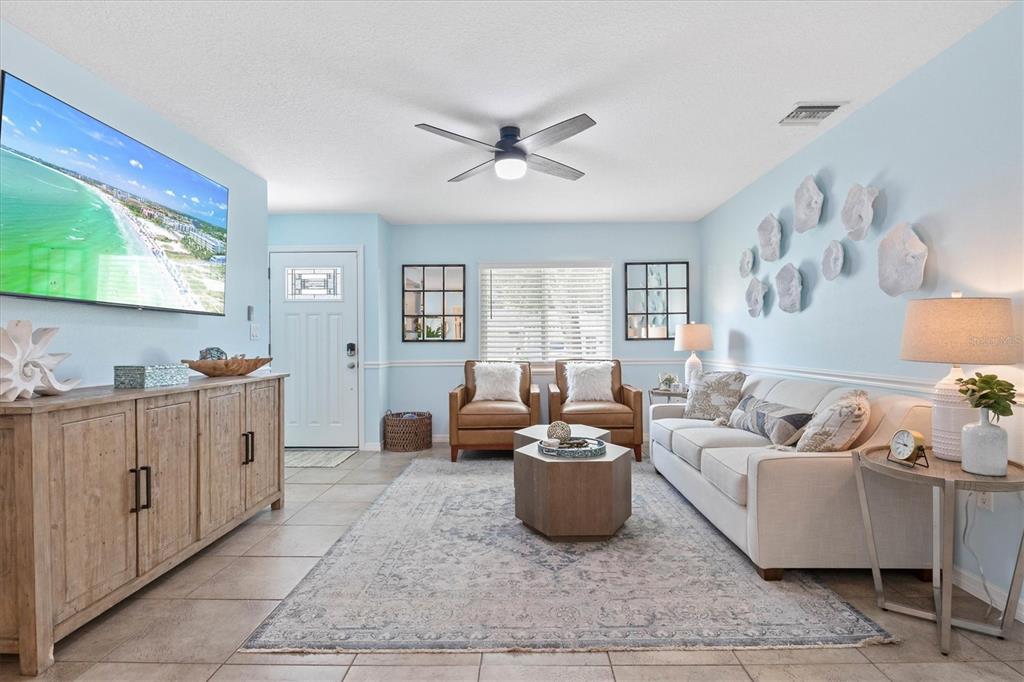A living room features light blue walls, a beige sofa, two leather chairs, and tile flooring — 2729 SYDELLE STREET, SARASOTA, FL