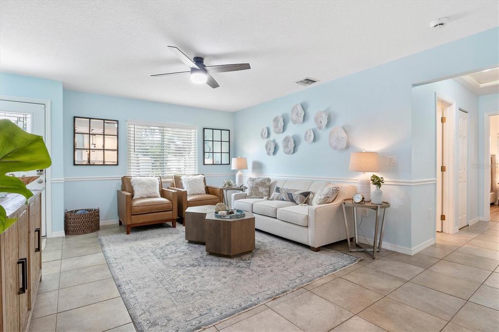 A living room features light blue walls, a beige sofa, two leather chairs, and tile flooring — 2729 SYDELLE STREET, SARASOTA, FL