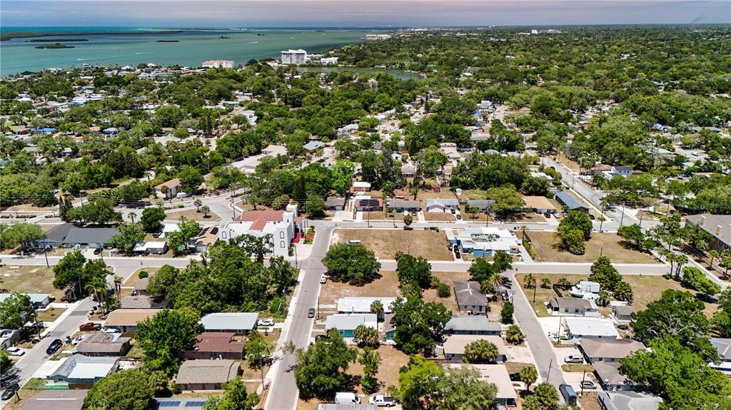 An aerial view shows a residential neighborhood with houses, streets, and trees near water — 1405 PENNSYLVANIA AVENUE, CLEARWATER, FL