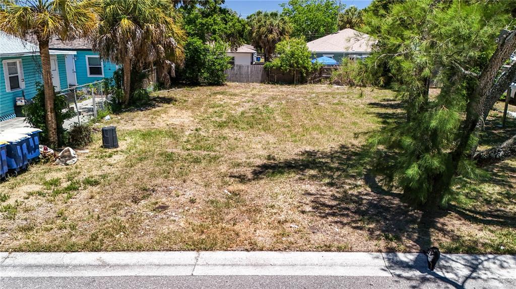 An elevated view shows a vacant, grassy residential lot bordered by trees and neighboring houses — 1405 PENNSYLVANIA AVENUE, CLEARWATER, FL