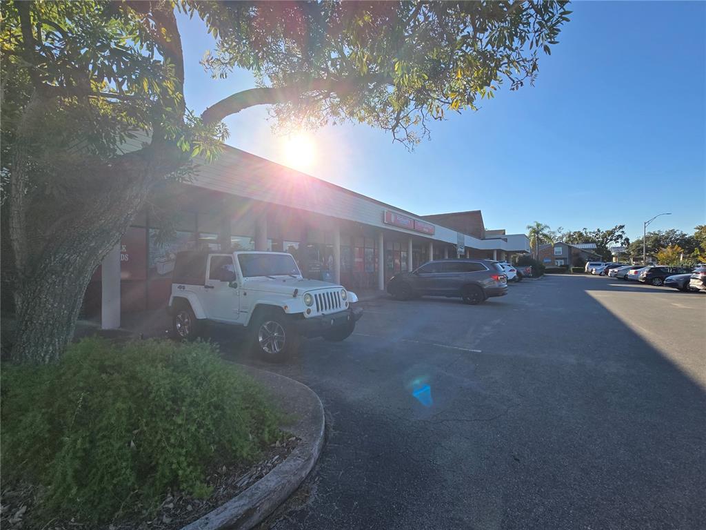 A white Jeep is parked in front of a commercial strip mall under a sunny sky — 2601 MANATEE AVENUE W, BRADENTON, FL