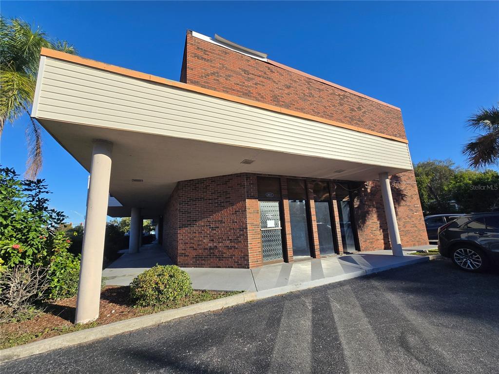 A brick commercial building with a covered entrance and large glass windows under a canopy — 2601 MANATEE AVENUE W, BRADENTON, FL