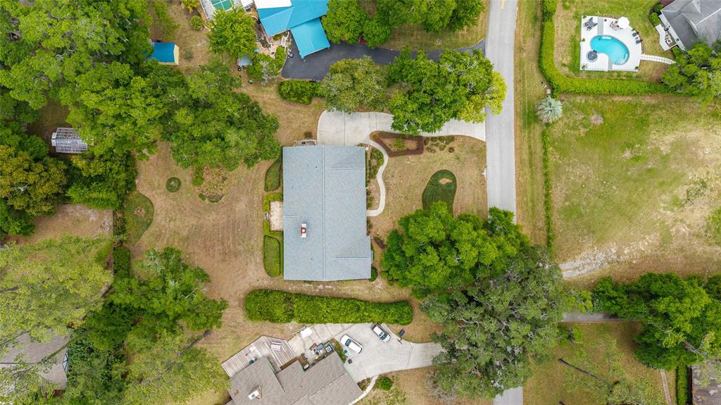 An aerial view shows a house with a gray roof surrounded by trees and lawns — 8051 NW 43RD LANE, OCALA, FL