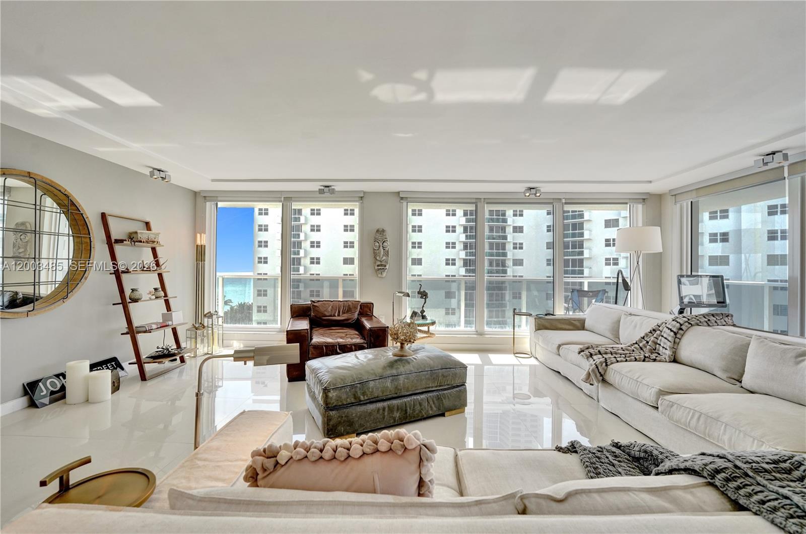 A bright living room features white tile floors, a large sectional sofa, and floor-to-ceiling windows — 2751 S Ocean Dr # 908S, Hollywood FL 33019, HOLLYWOOD, FL