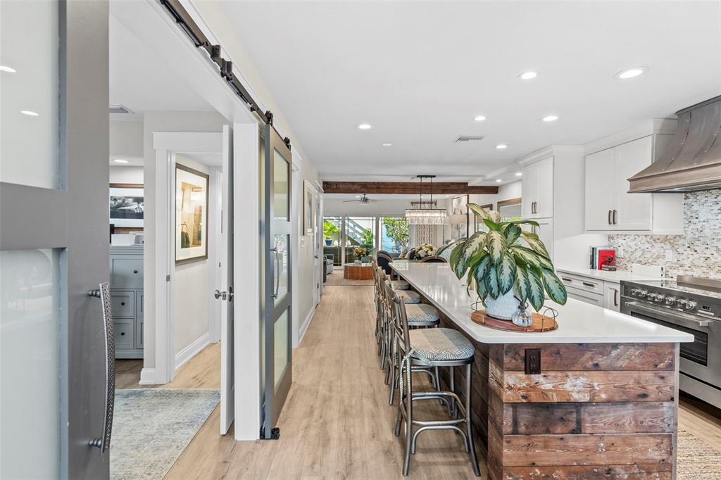 A kitchen with a long island, rustic wood base, and bar seating overlooks a living area — 5013 S ELBERON STREET, TAMPA, FL