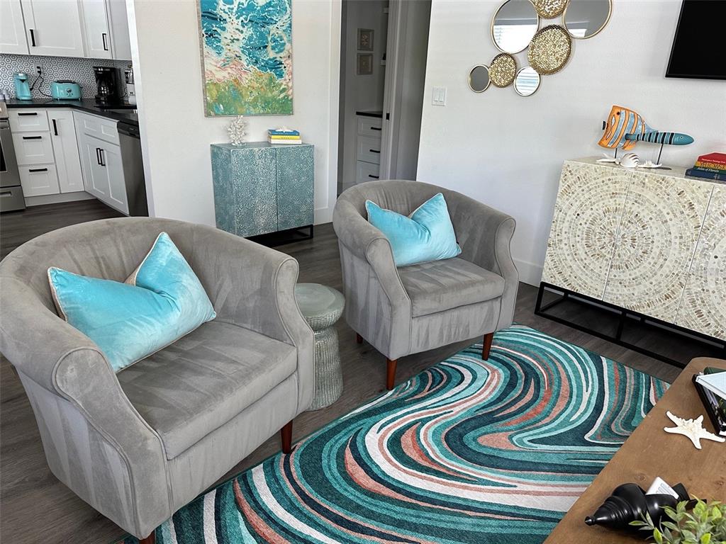 Two gray armchairs with blue pillows sit on a wavy rug in a living area — 1910 MORRILL STREET UNIT 6, SARASOTA, FL