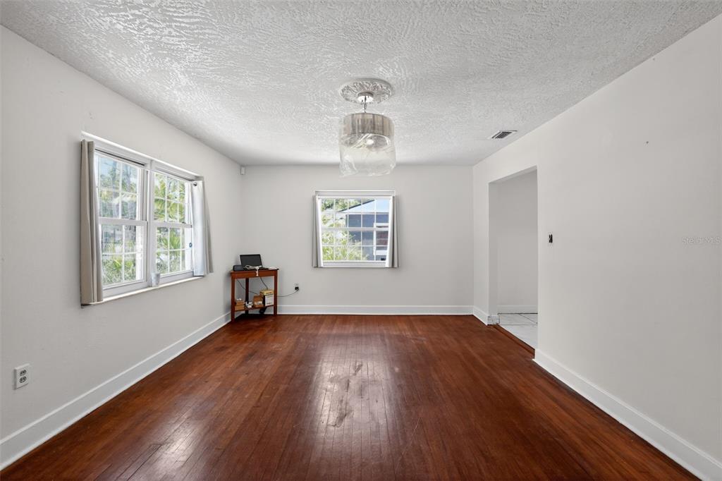 An empty room with hardwood floors, white walls, two windows, and a ceiling light fixture — 775 28TH AVENUE S, ST PETERSBURG, FL