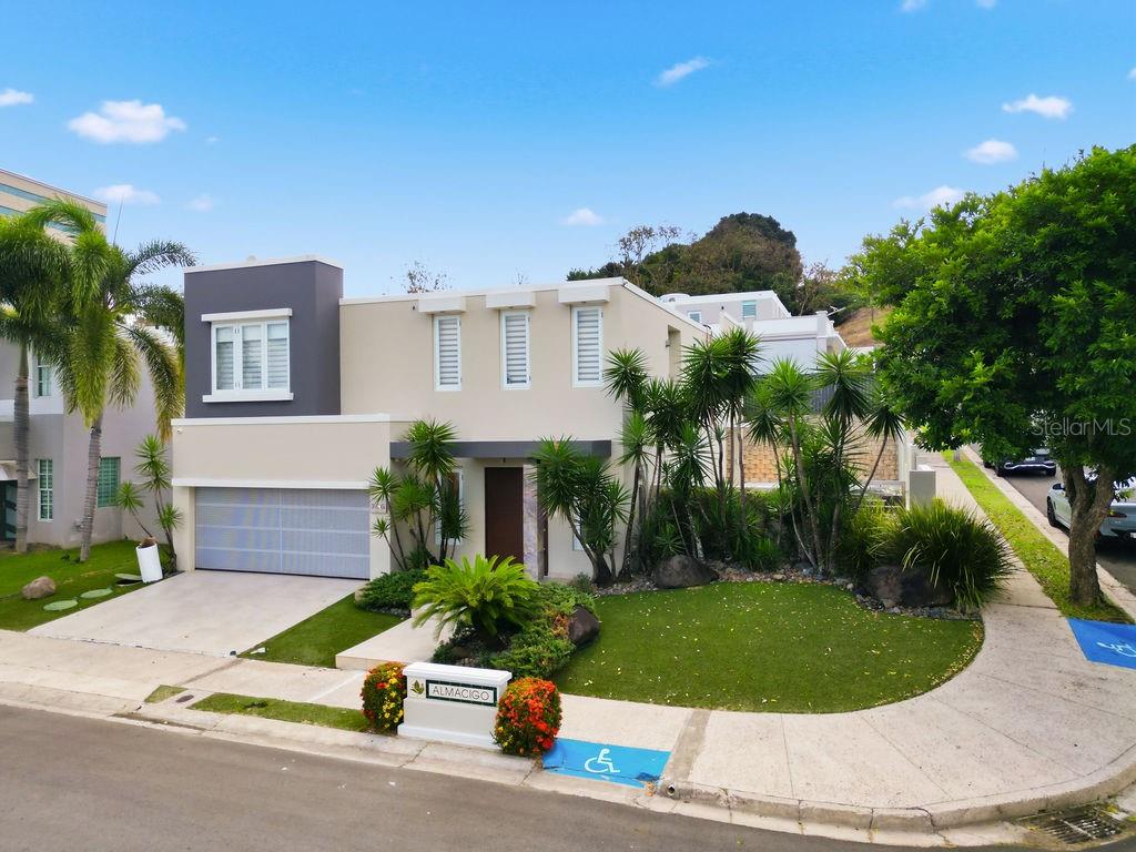 A two-story modern house with a garage, landscaped front yard, and a paved driveway — 366 ALMACIGO, SAN JUAN, PR