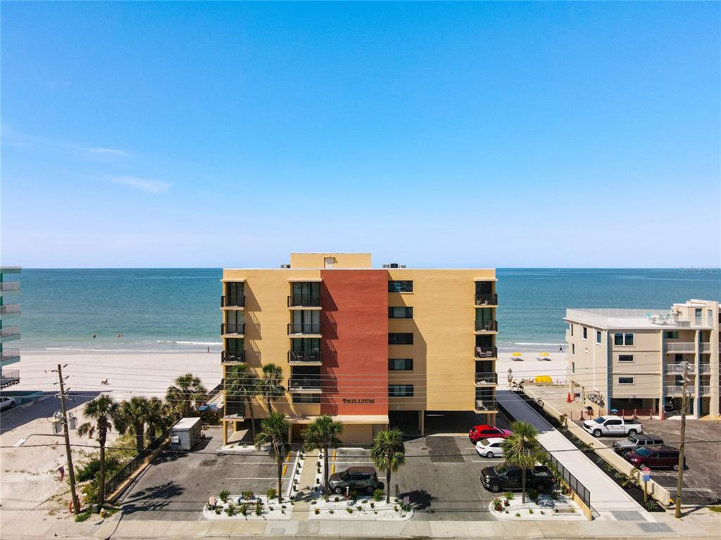 An aerial view of a multi-story beachfront condominium building with a parking lot — 14146 GULF BOULEVARD UNIT 3A, MADEIRA BEACH, FL