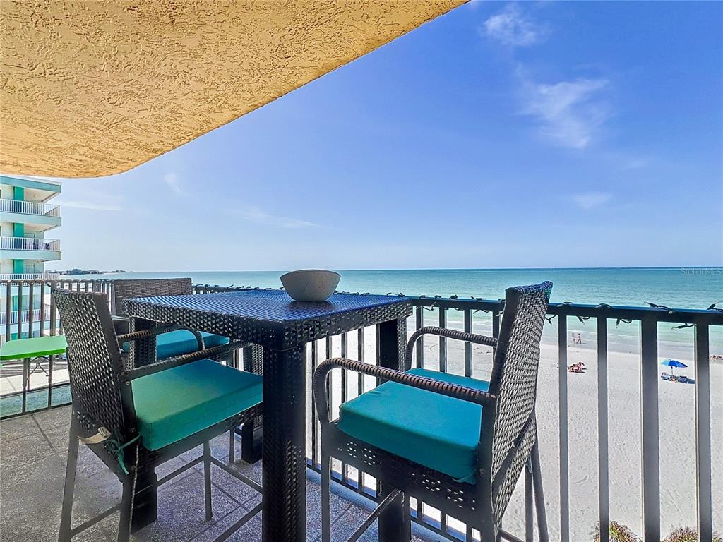 A balcony with patio furniture overlooks a sandy beach and the ocean — 14146 GULF BOULEVARD UNIT 3A, MADEIRA BEACH, FL