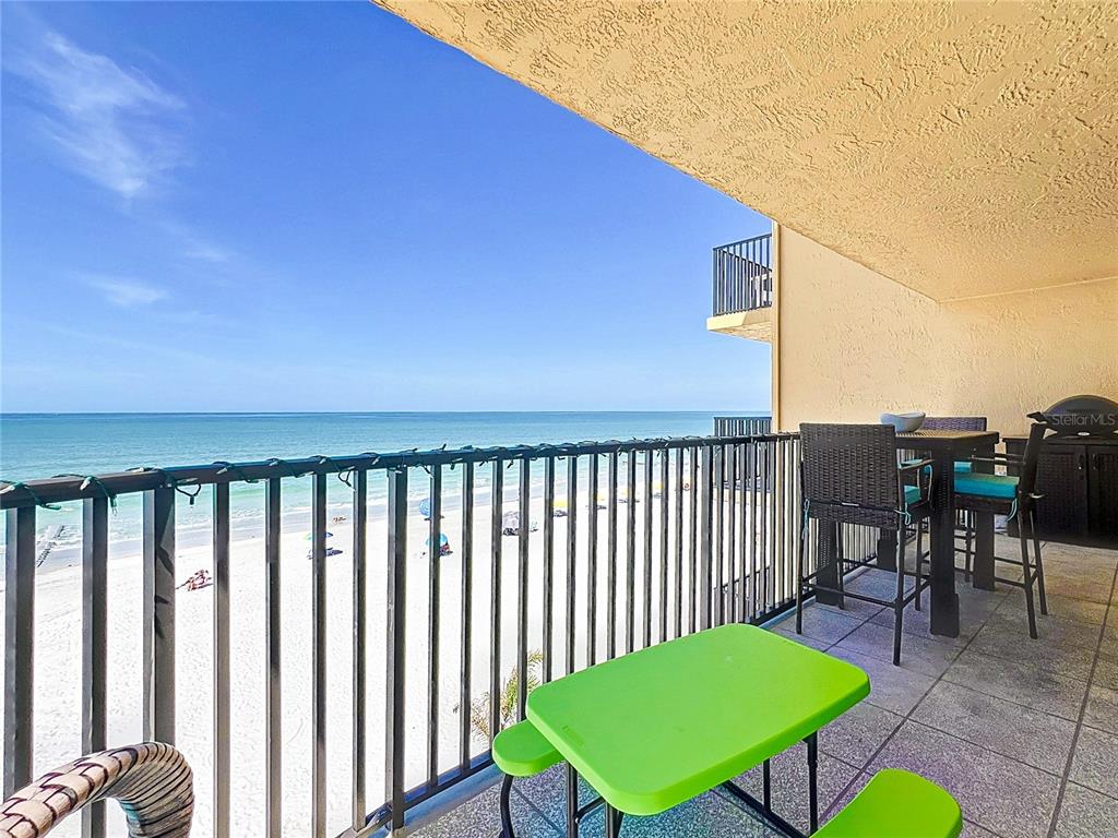 A balcony with a metal railing overlooks a sandy beach and the ocean — 14146 GULF BOULEVARD UNIT 3A, MADEIRA BEACH, FL