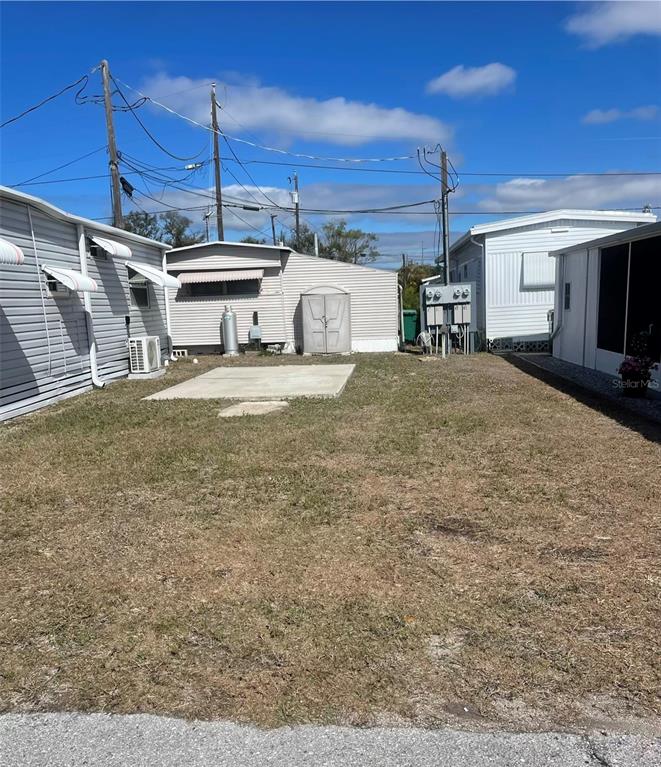 A grassy lot sits between two mobile homes with a concrete pad and utility shed — 92 MICHIGAN STREET, PALMETTO, FL