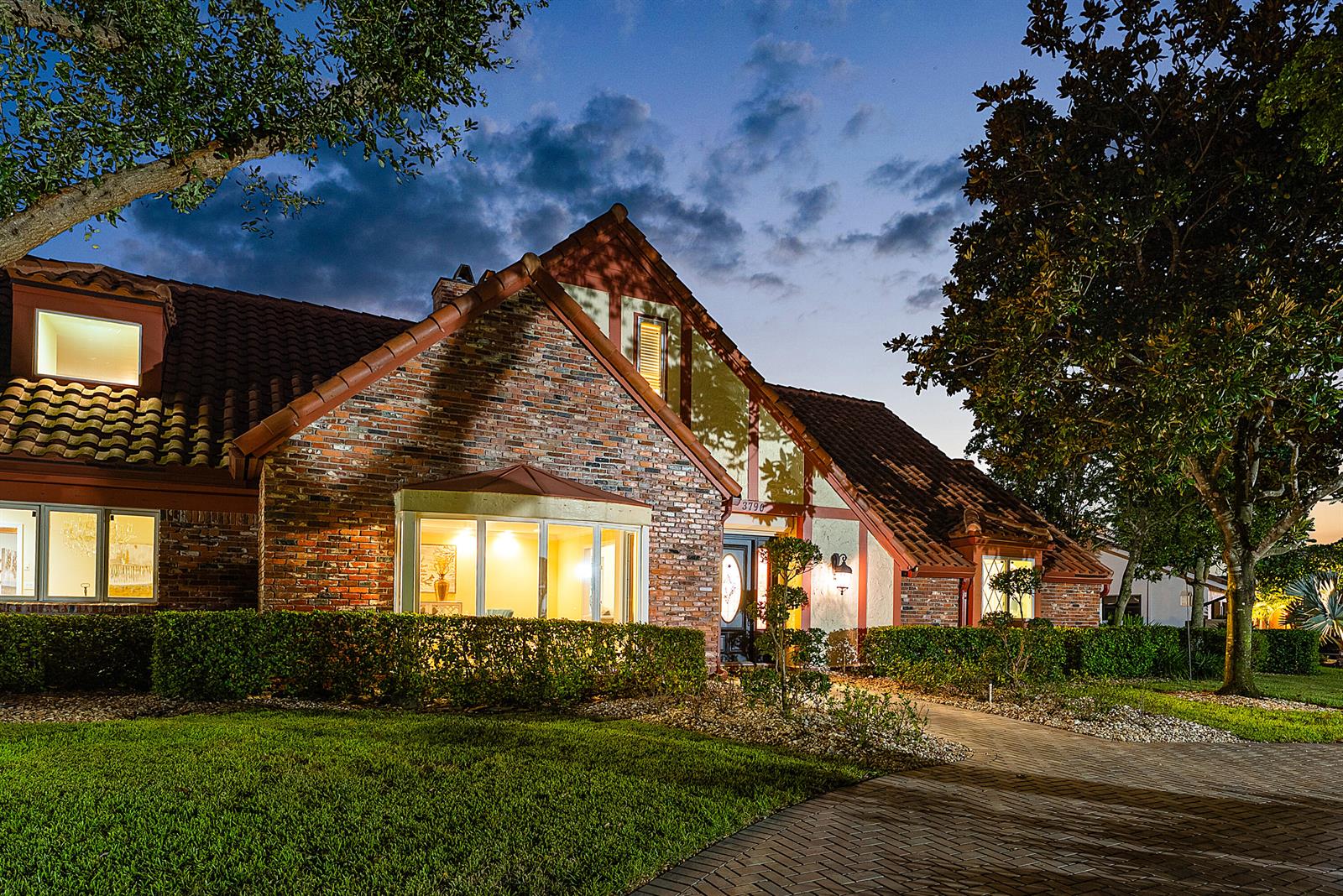 A brick house with a tiled roof and a bay window at twilight — 3790 Kings Way, Boca Raton FL 33434, BOCA RATON, FL