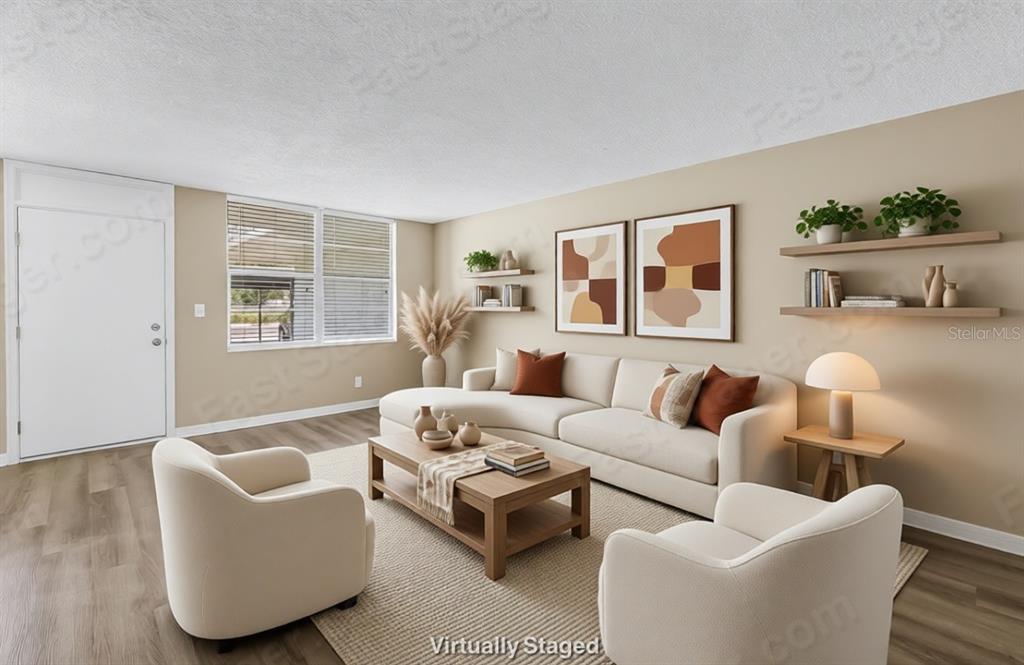 This is a virtually staged living room with a beige sofa, two armchairs, and wood flooring — 4720 LOCUST STREET NE UNIT 116, ST PETERSBURG, FL