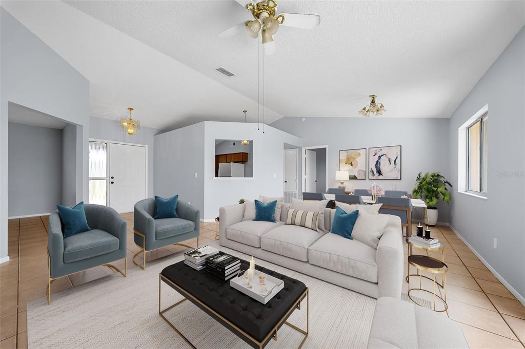 A living room with light blue walls, tile flooring, a white sofa, and two armchairs — 7853 KENSINGHAM COURT, ORLANDO, FL