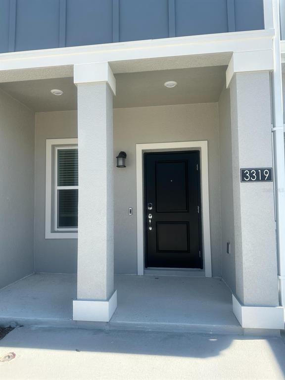The exterior view shows a covered front porch with a black door and address plaque — 3319 LAURENT LOOP UNIT 3319, DAVENPORT, FL