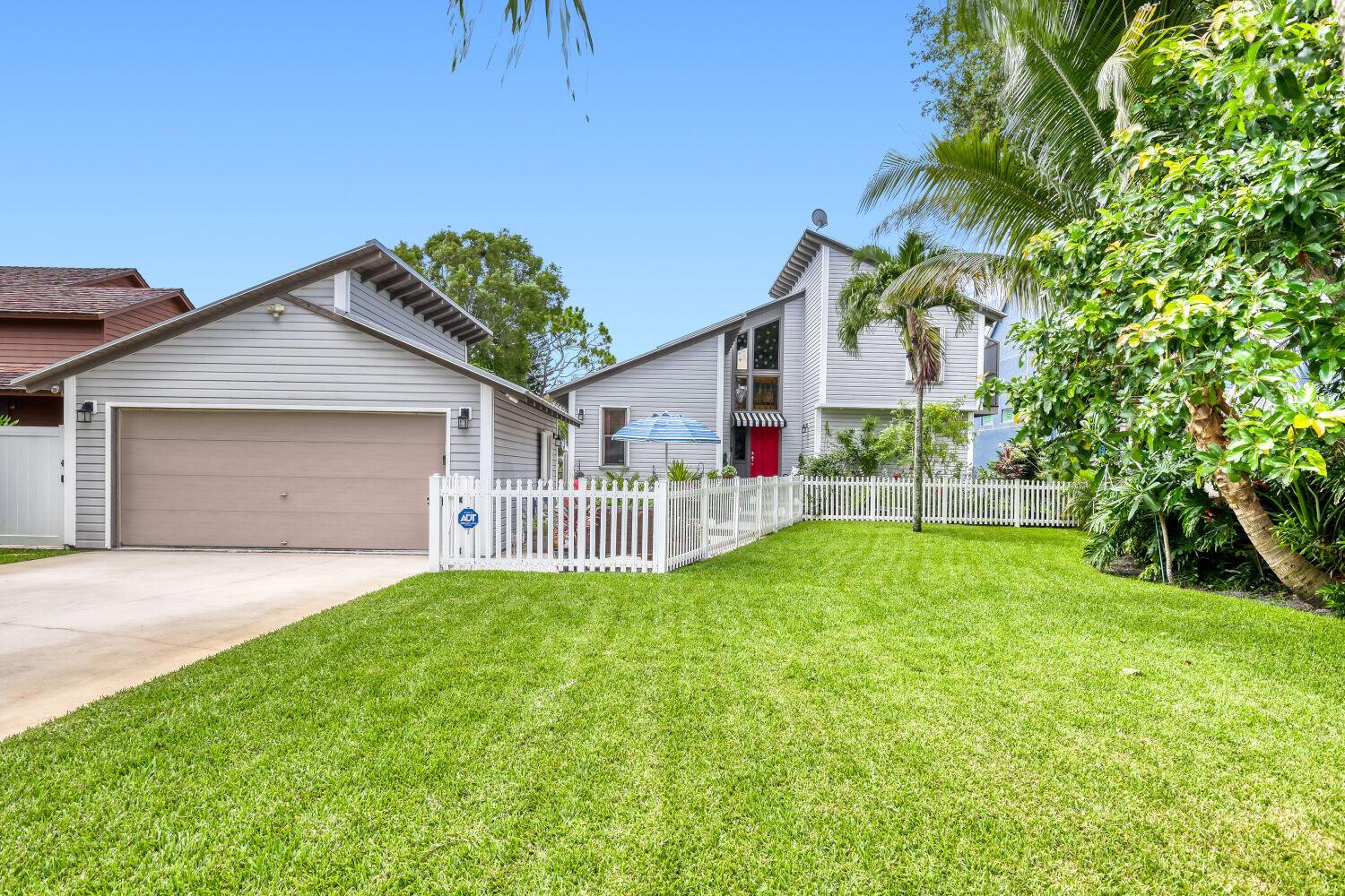 A gray two-story house with a detached garage and a white picket fence in front — 3918 Edgar Avenue, Boynton Beach FL 33436, BOYNTON BEACH, FL