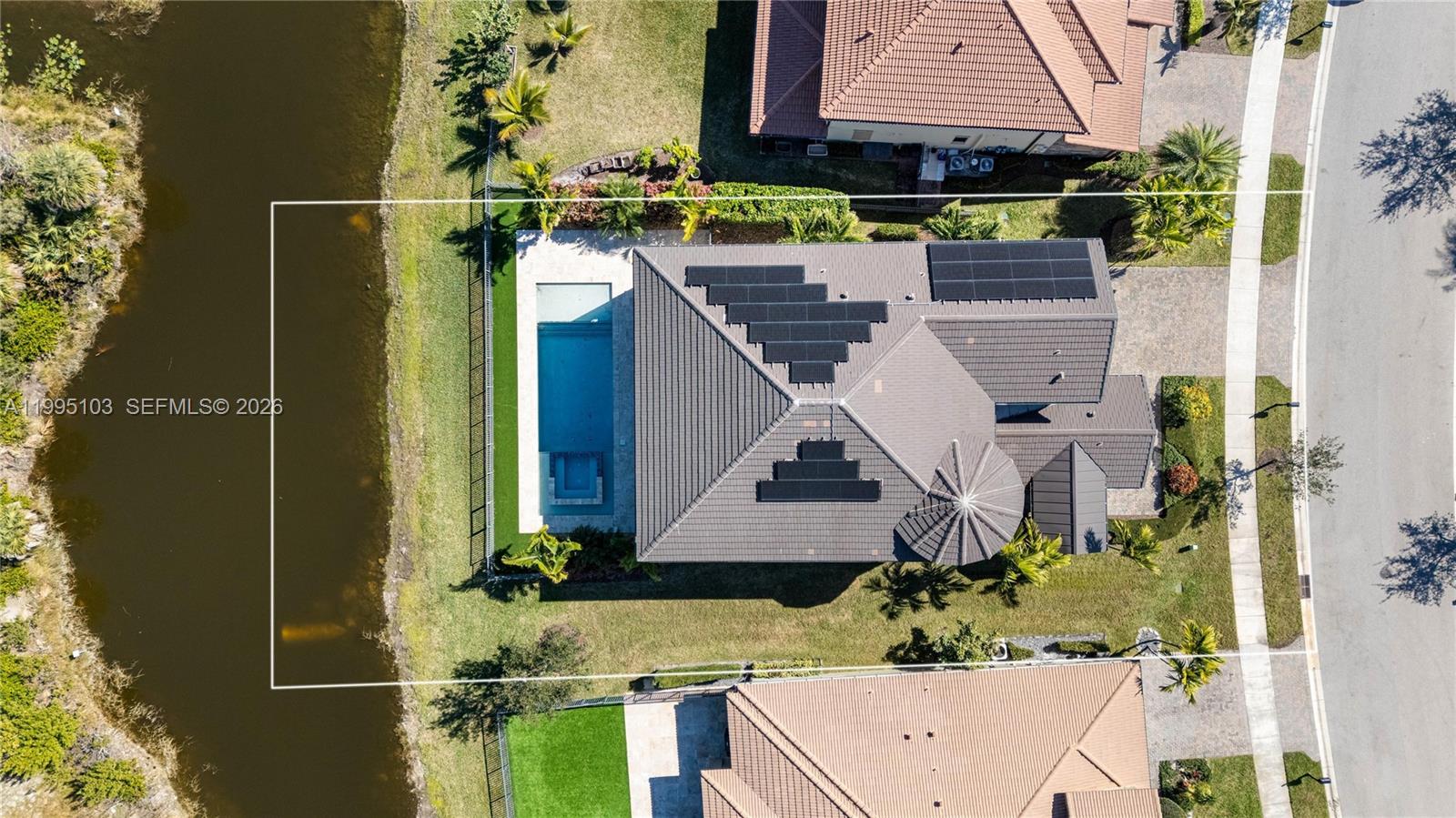 An aerial view shows a house with solar panels, a swimming pool, and a backyard pond — 11475 Watercrest Circle East, Parkland FL 33076, PARKLAND, FL