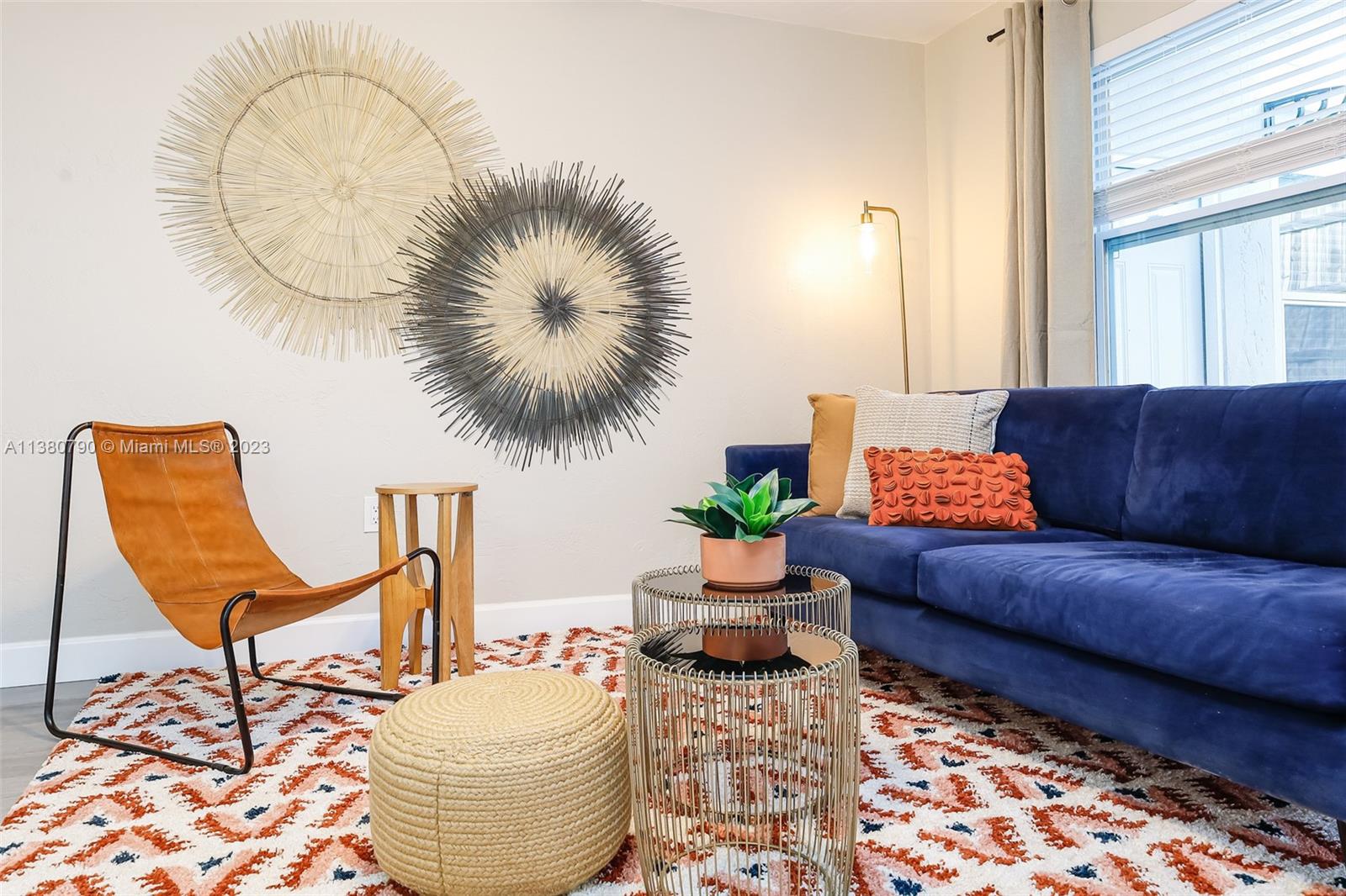 A living room features a blue sofa, a leather chair, and two circular wall decorations — 2761 SW 33rd Ave # 2, Miami FL 33133, MIAMI, FL