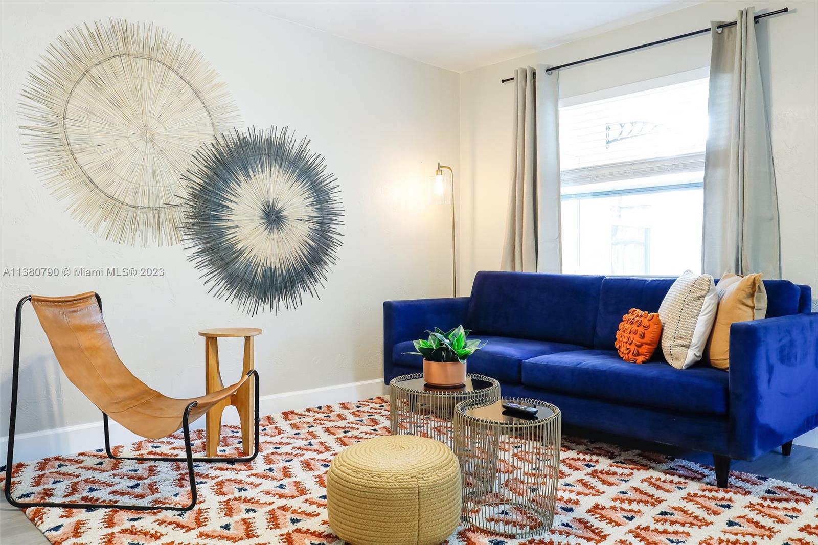 A living room features a blue sofa, a leather chair, and wall-mounted circular art — 2761 SW 33rd Ave # 2, Miami FL 33133, MIAMI, FL