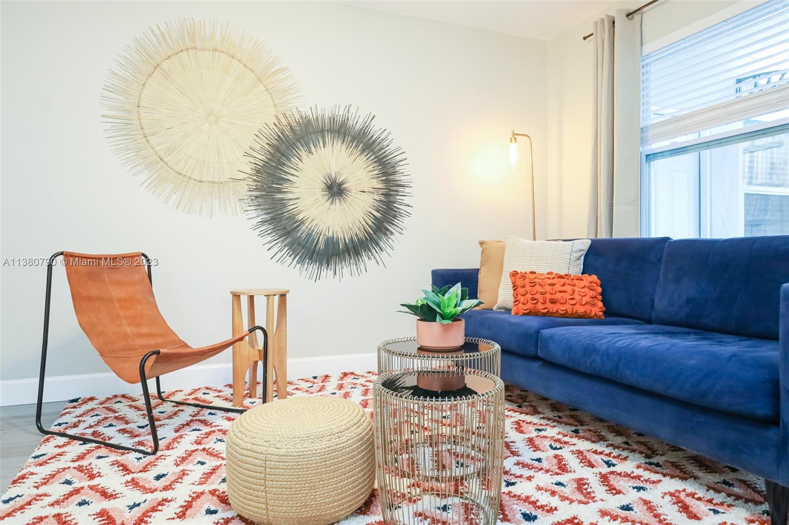 A living room features a blue sofa, a leather chair, and two circular wall decorations — 2761 SW 33rd Ave # 2, Miami FL 33133, MIAMI, FL