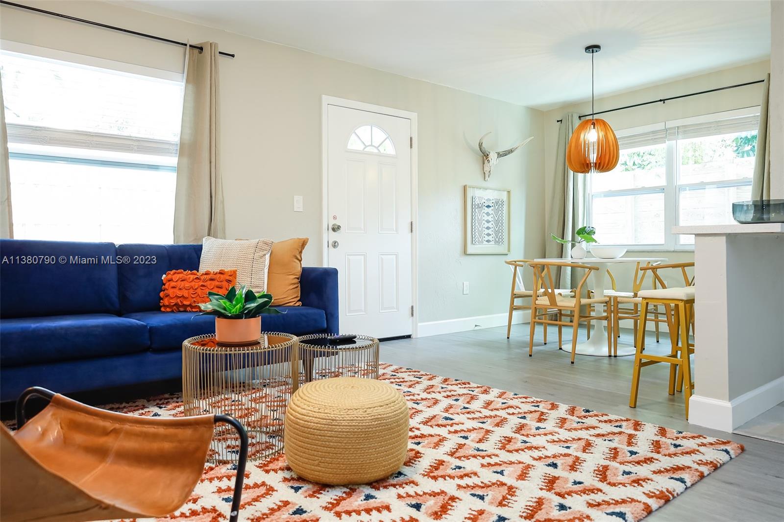 A living room features a blue sofa, patterned rug, and a dining area with pendant lighting — 2761 SW 33rd Ave # 2, Miami FL 33133, MIAMI, FL