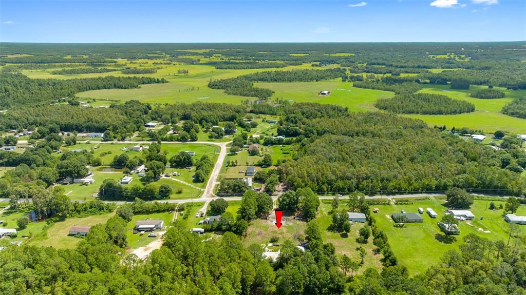 An aerial view shows a rural residential lot marked by a red arrow — 3207 CYPRESS TRAILS DRIVE, POLK CITY, FL