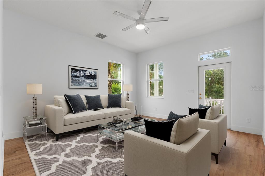 A living room features a beige sofa, two armchairs, a glass coffee table, and hardwood floors — 385 GEORGIA AVENUE, CRYSTAL BEACH, FL