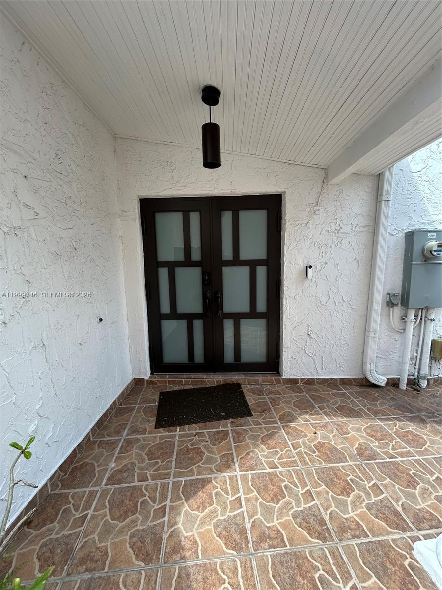 A covered entryway features a dark double door with frosted glass panels and tiled flooring — 13267 SW 9th Ln, Miami FL 33184, MIAMI, FL