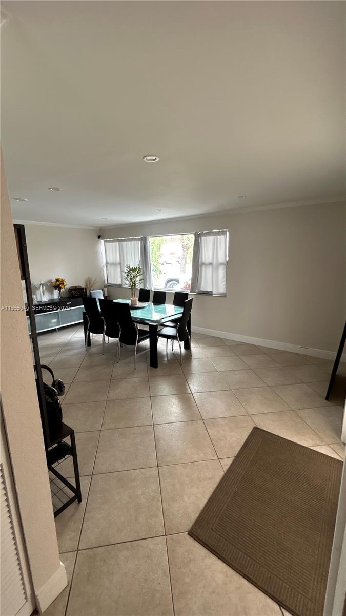 A dining area features a glass-topped table, black chairs, and light-colored tile flooring — 13267 SW 9th Ln, Miami FL 33184, MIAMI, FL