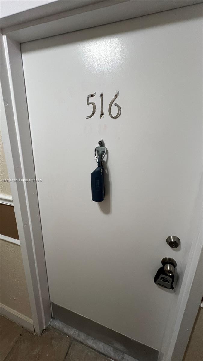 A white apartment door labeled 516 features a door knocker and a lockbox — 4550 NW 9th St # 516E, Miami FL 33126, MIAMI, FL